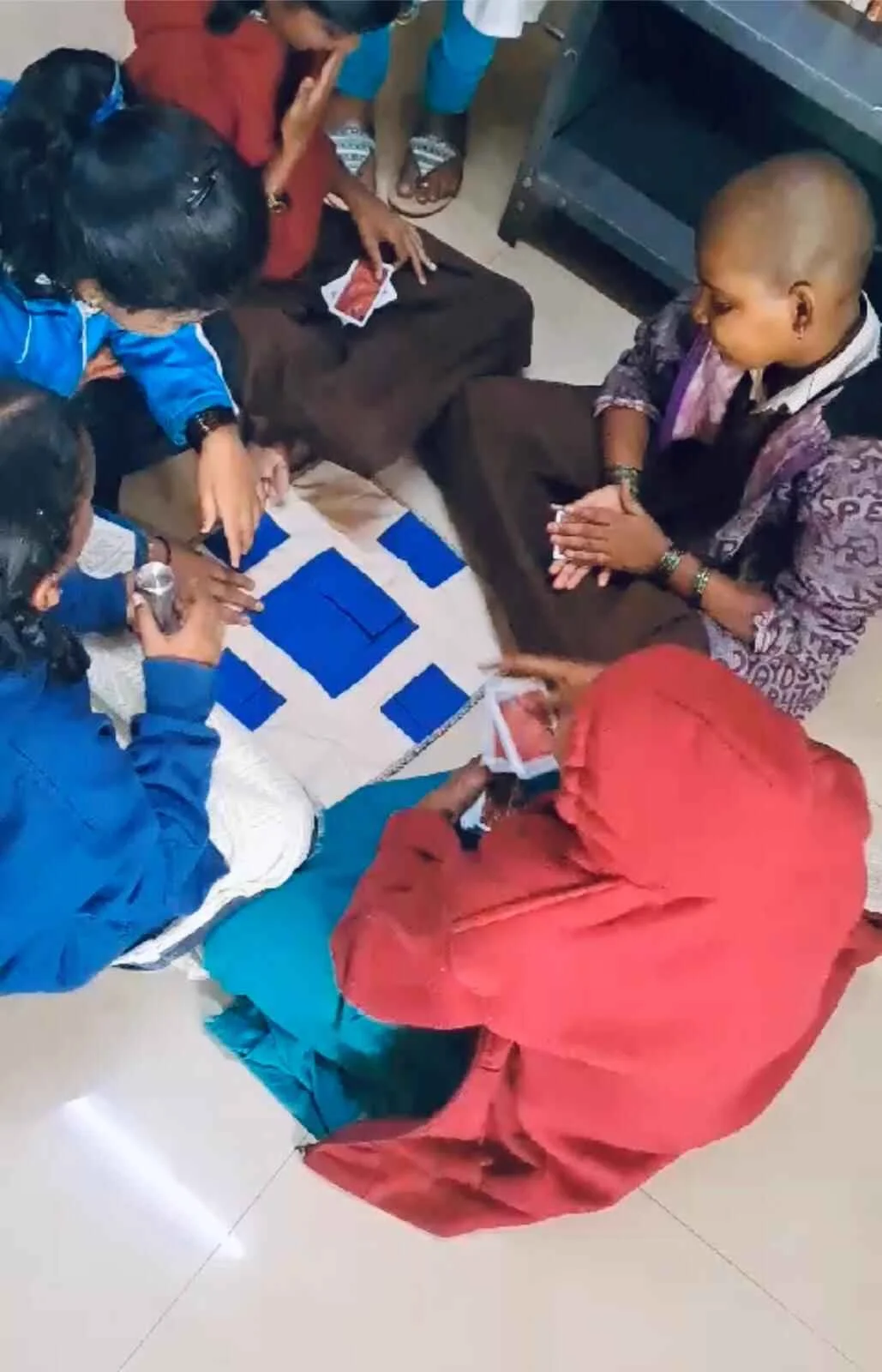 Group laughing and playing with Junior braille playing cards.